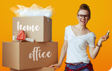 smiling woman beside two cardboard boxes labelled home and office