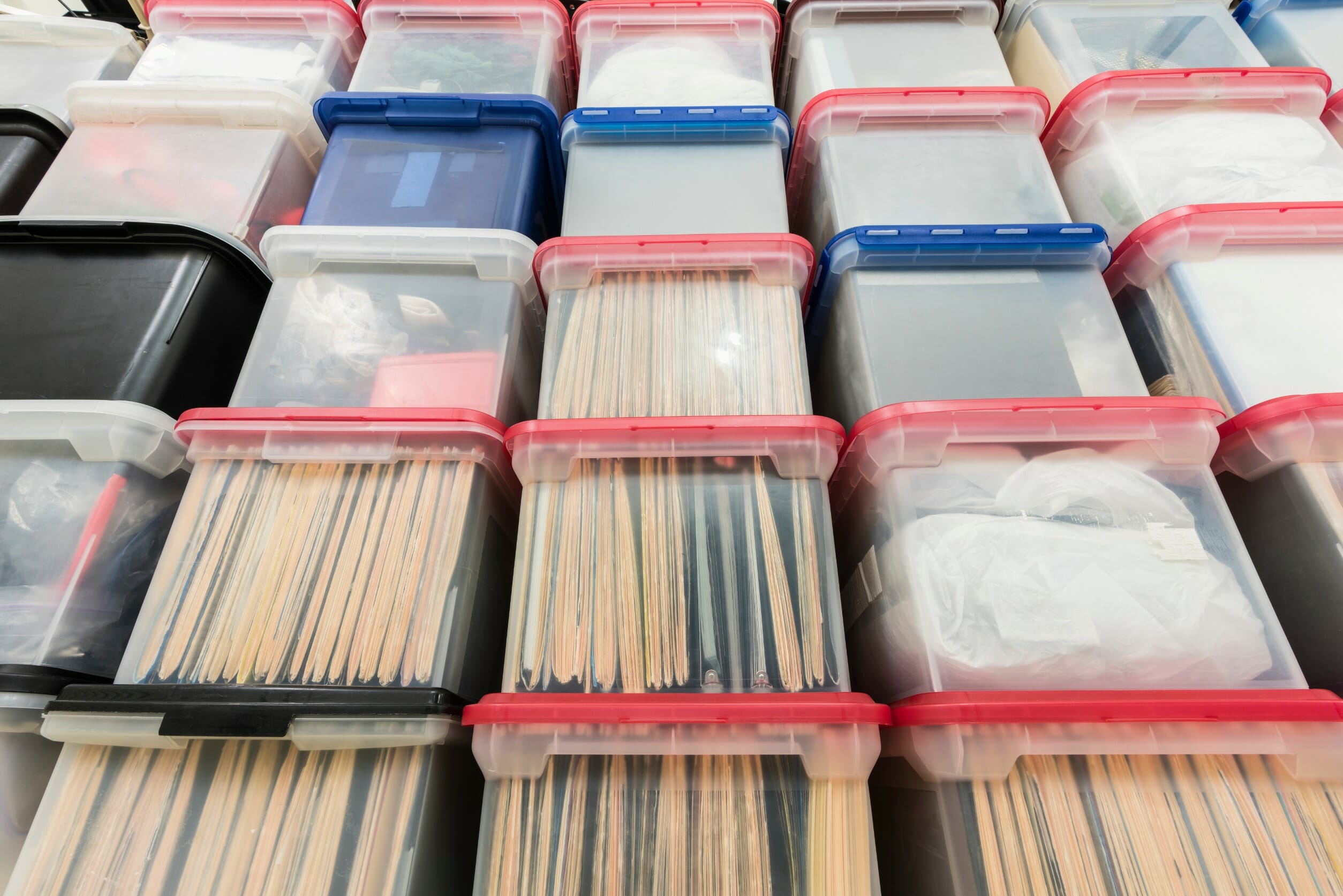 A stack of see-through plastic storage totes
