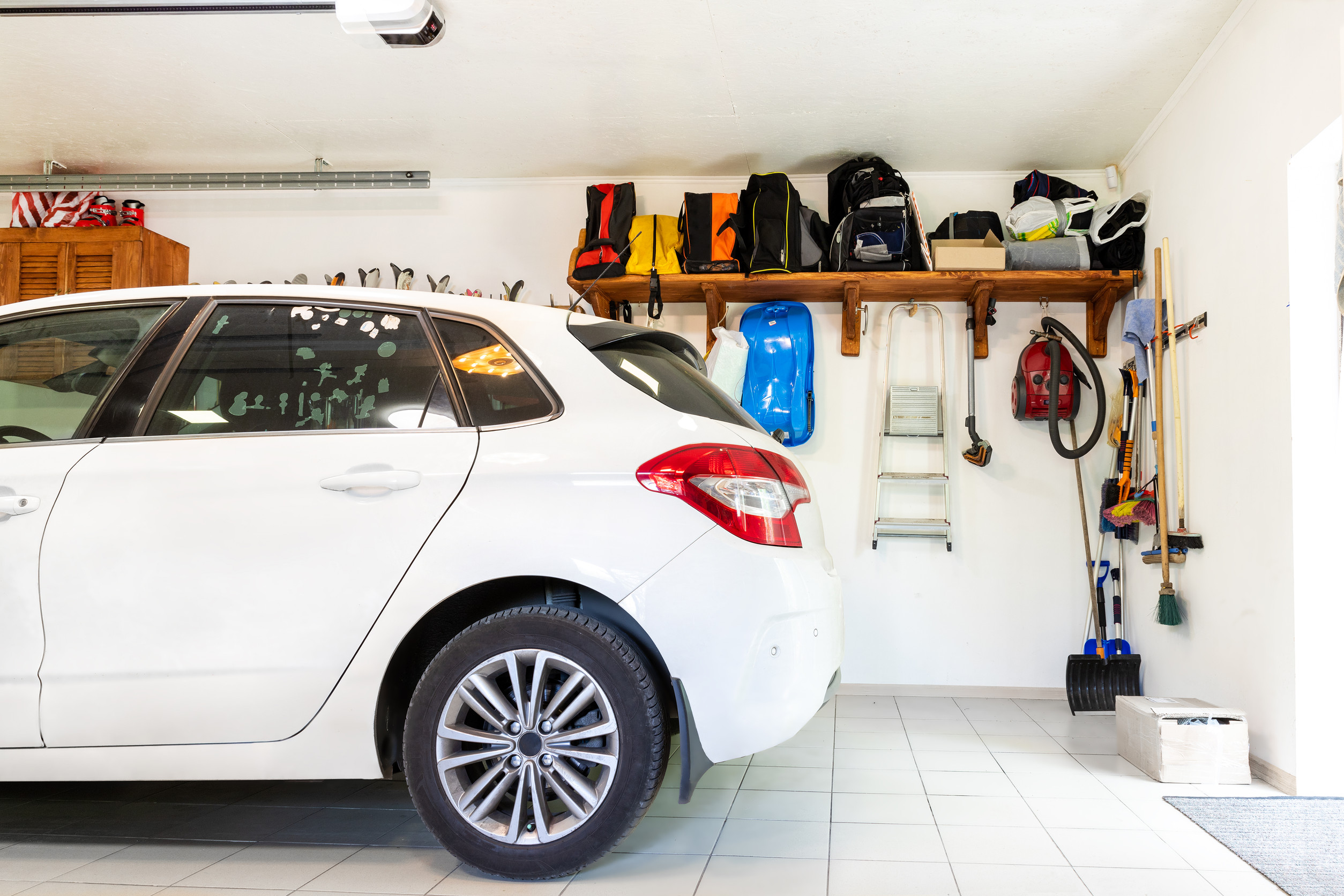White car parked inside a neat, tidy home garage